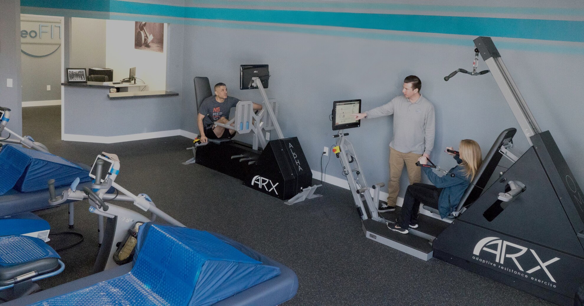 Personal trainers working with clients on various machines at Leo’s Fitness Lab.