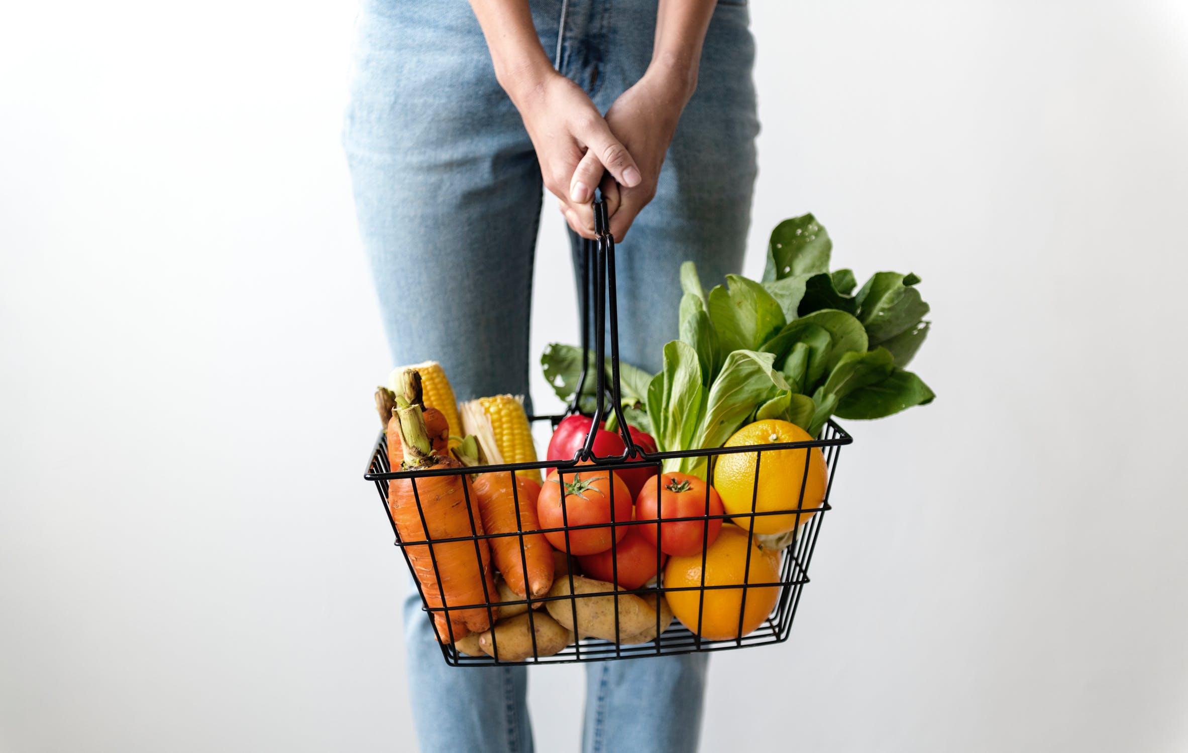 Woman carrying basket of veggies.