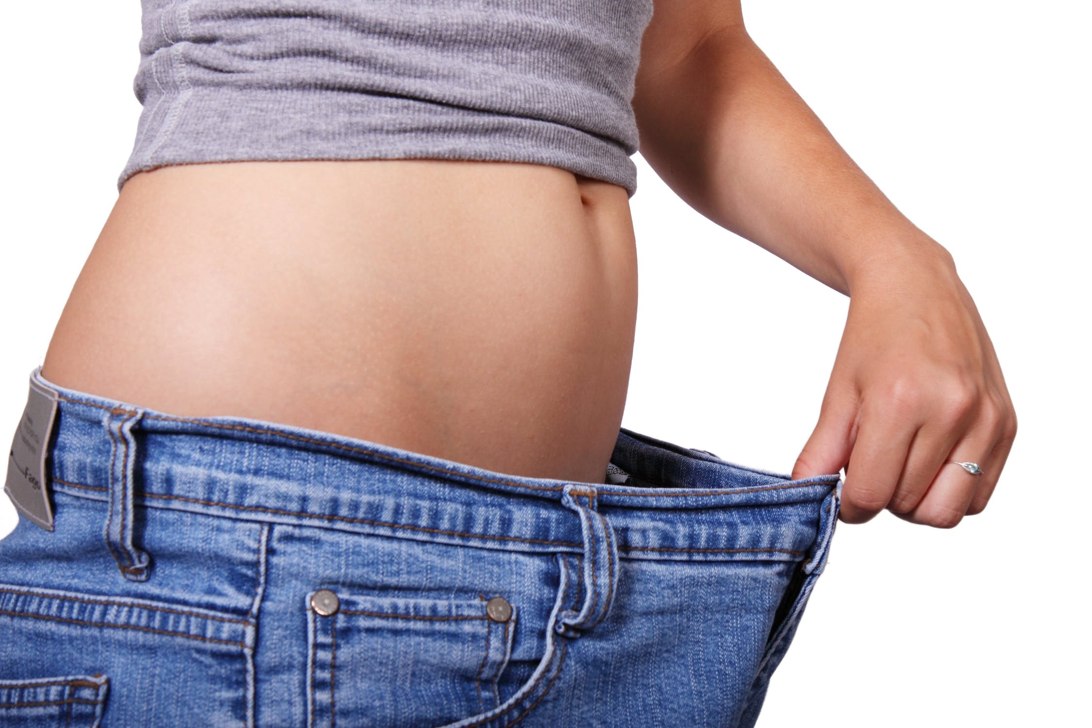 Woman stretching pants out to show weight loss.