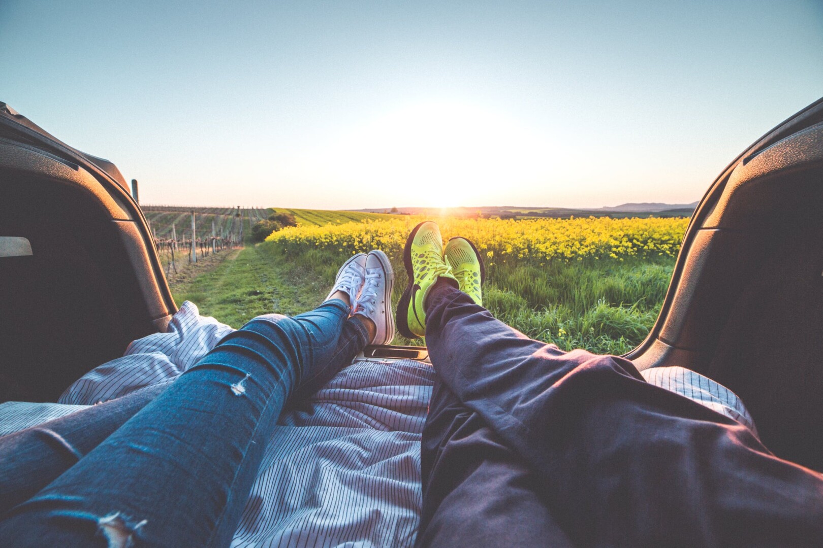 People laying in the bed of a truck at sunset.