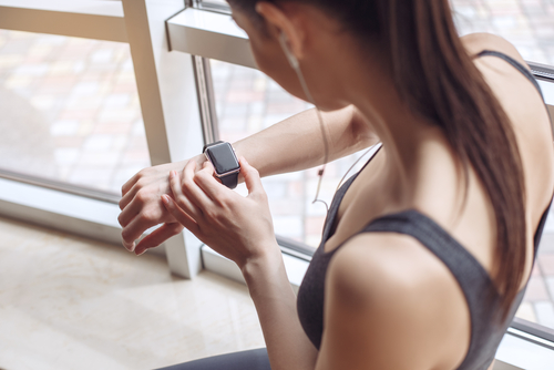 Woman setting health settings on fitness watch before working out.