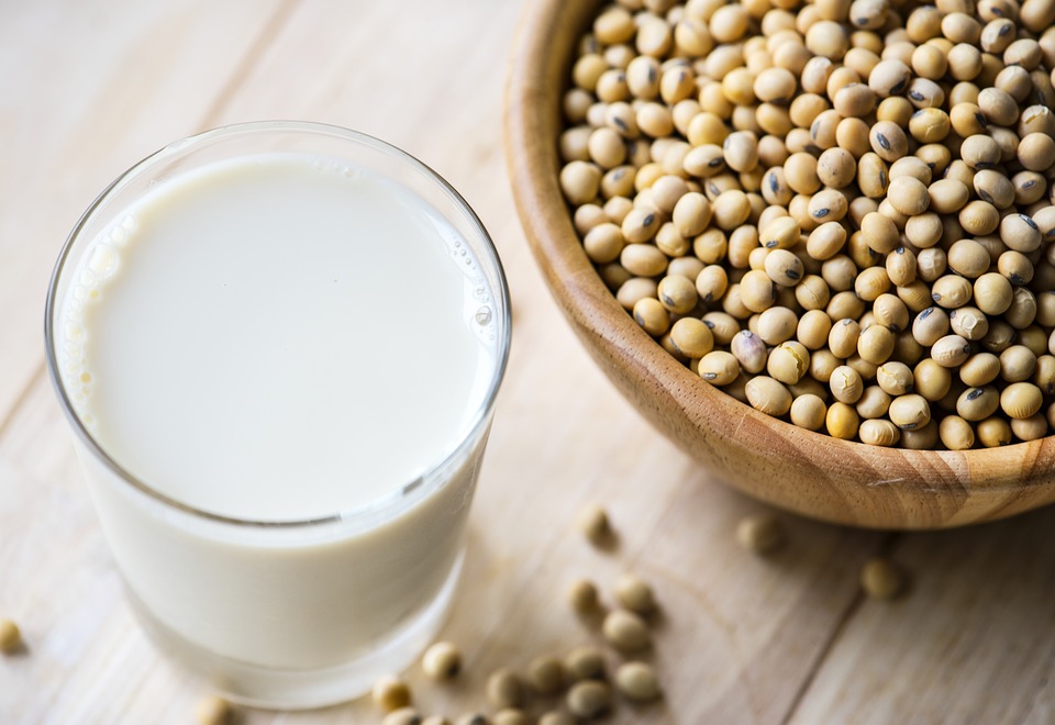 Bowl of beans next to a glass of soy milk.