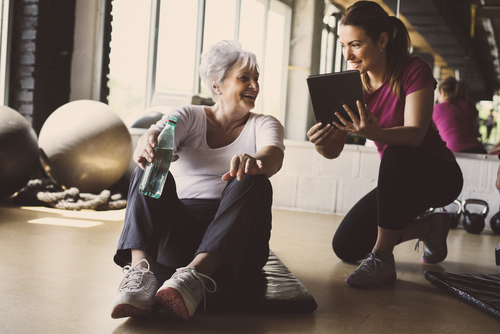 Older woman working out with personal trainer.