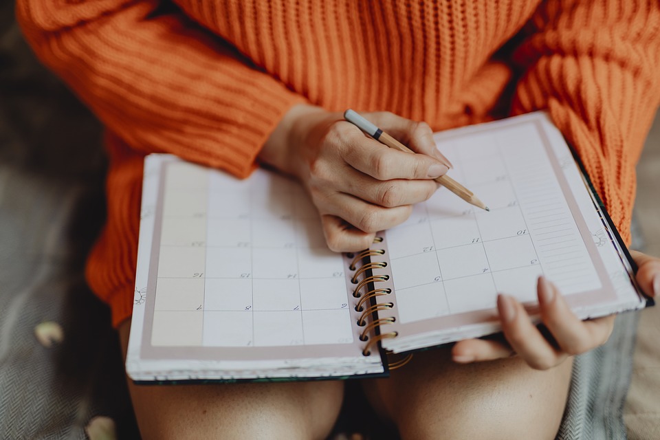 Woman writing in calendar planner.