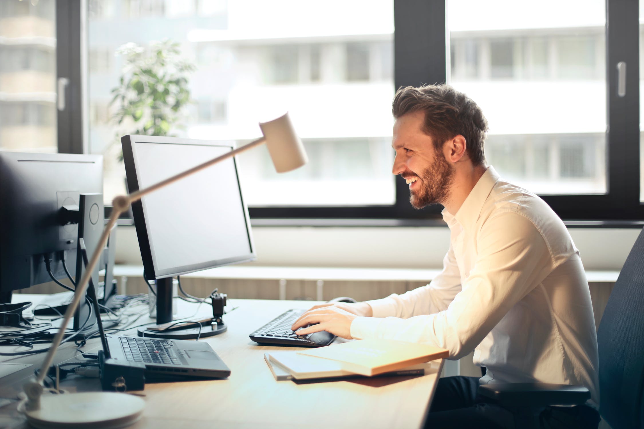 Man sitting at desk working on computer.