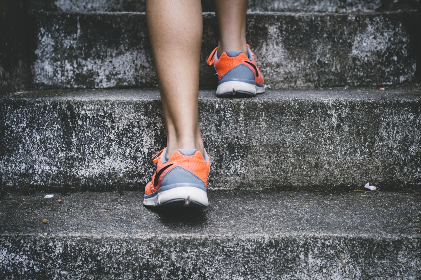 Close-up of woman running up a staircase.