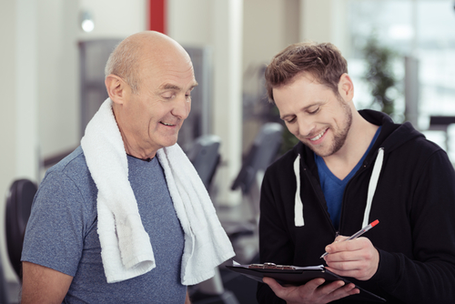 Older man and personal trainer doing fitness assessment.