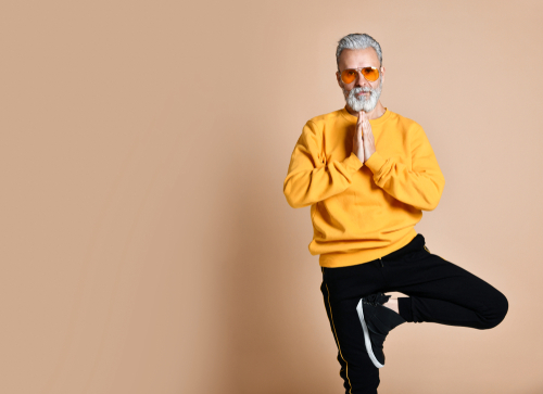 Older man standing in yoga pose.