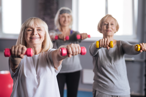 Three older women working out with dumbbells.