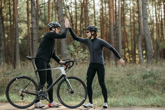 Two bikers high fiving.