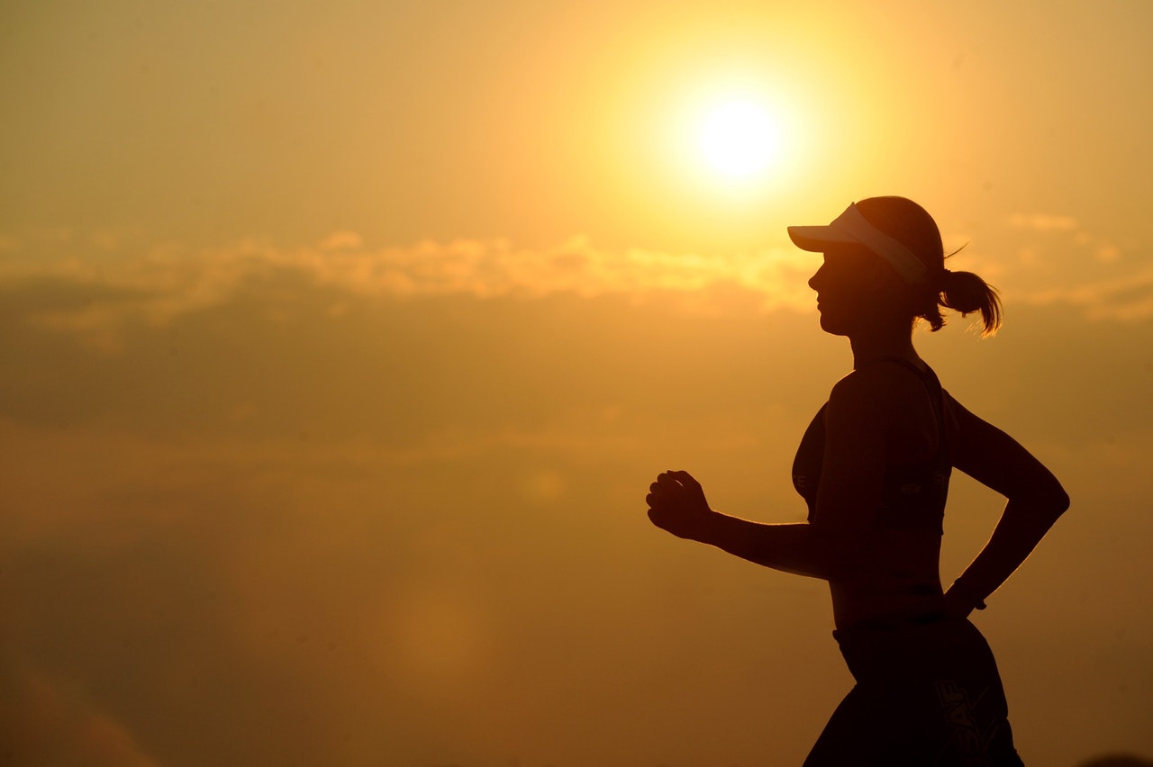 Woman running at sunrise.
