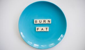 Dinner plate with scrabble tiles spelling out "burn fat."
