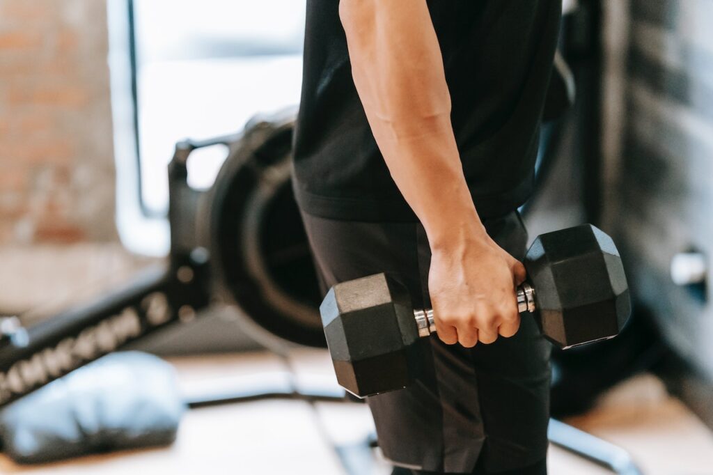 Close-up of a man lifting dumbbells.