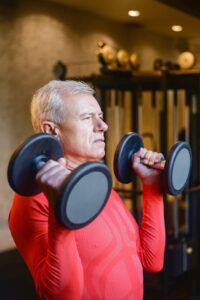 Older man lifting dumbbells.