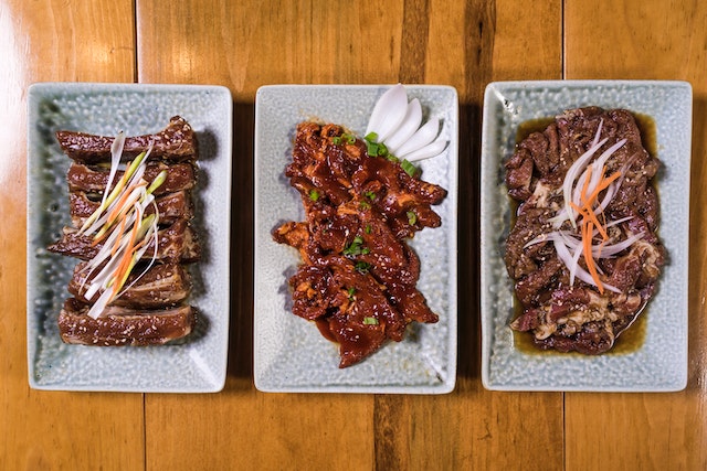 Three plates with various cooked meats.