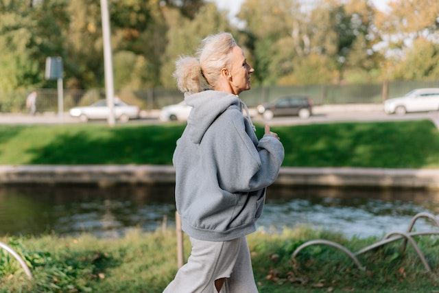 Older woman running in a park.