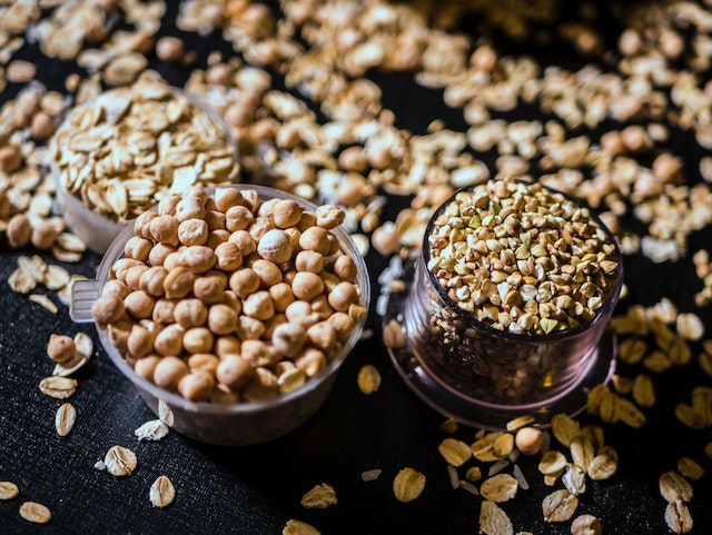 Two cups and a table full of granola and nuts.