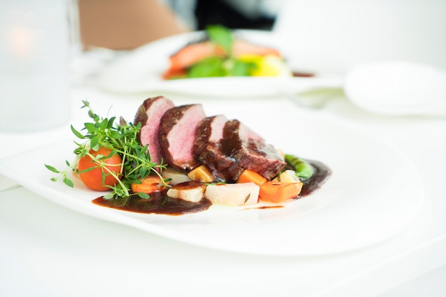 Dinner plate with sliced steak and veggies.