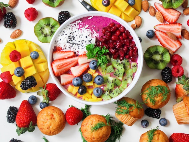 Table assorted with various tropical fruits, centered with an açaí bowl.