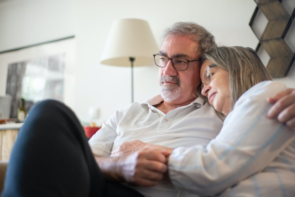 Senior couple embracing on a couch.