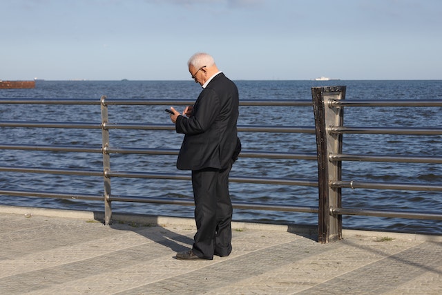 Man on cell phone at pier.