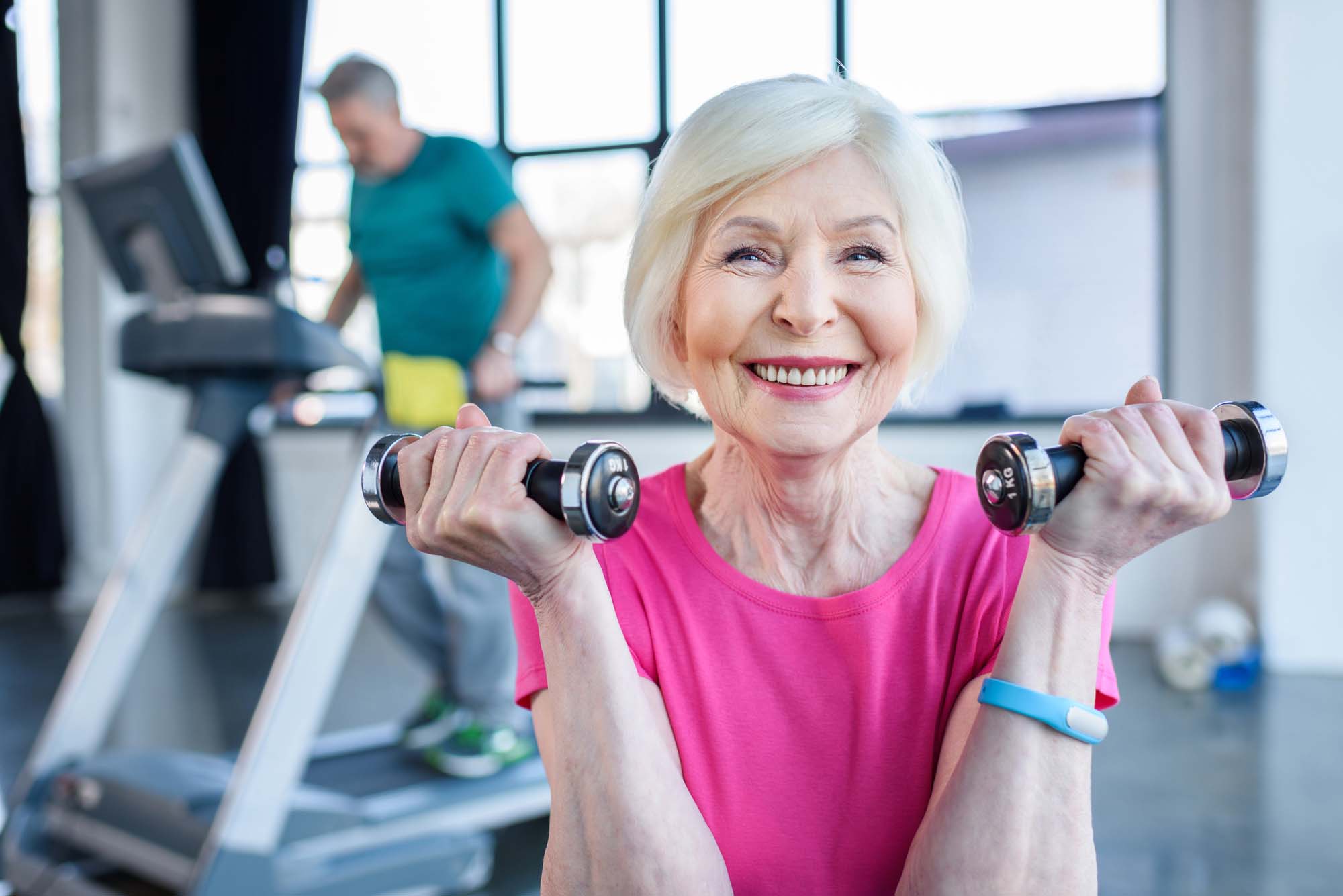 Older woman working out with smaller dumbbells.