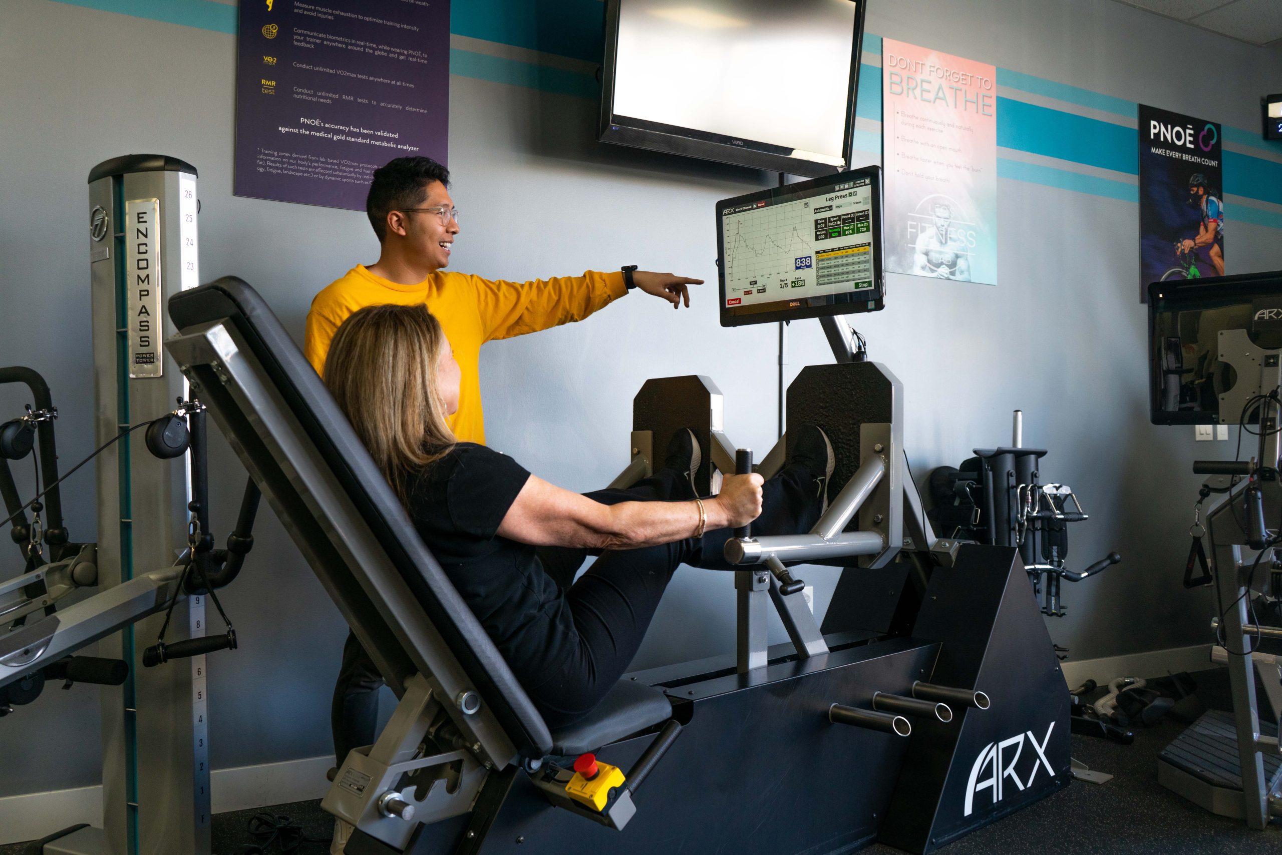 Client and personal trainer working out on the ARX machine at Leo's Fitness Lab.