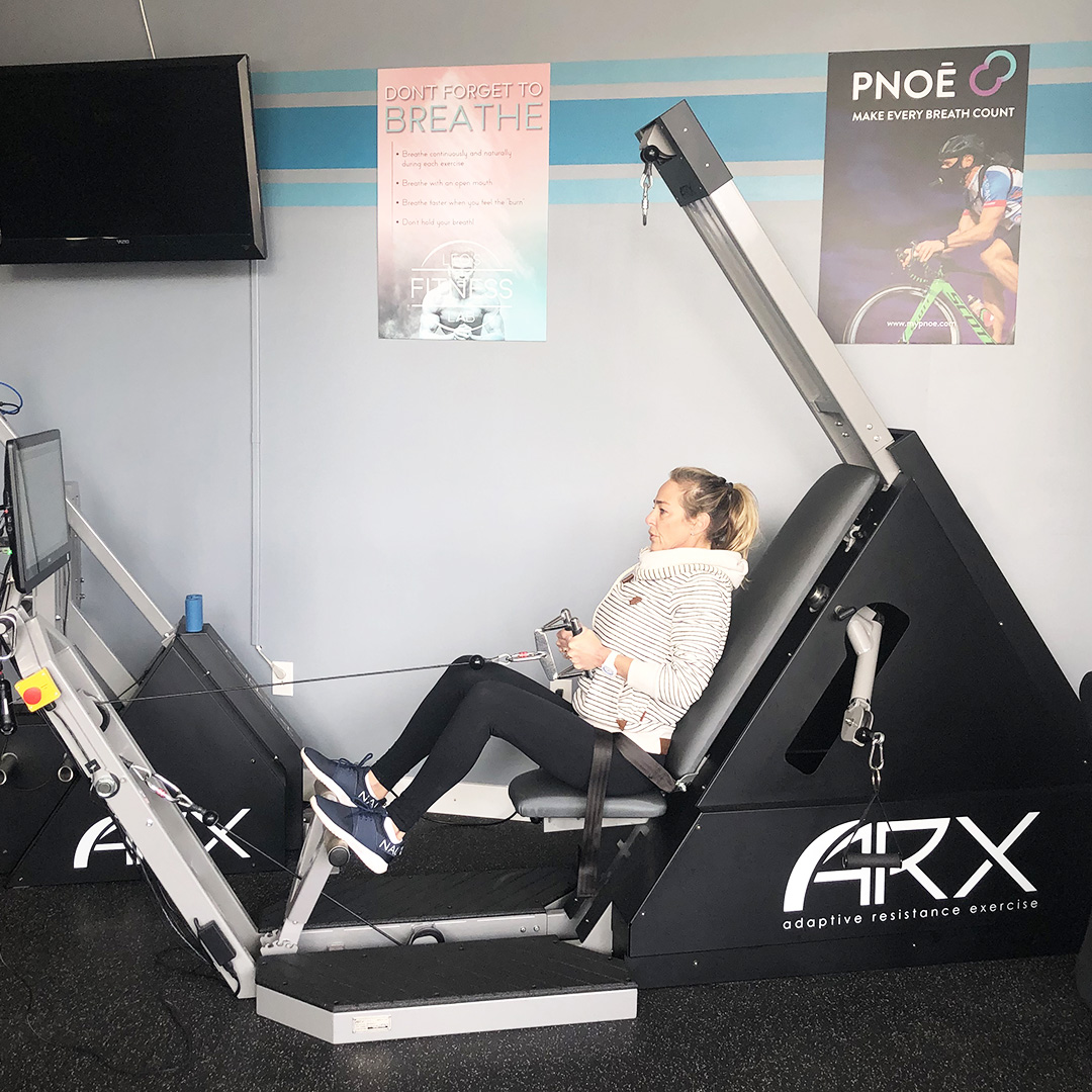 Senior woman working out on ARX machine in Leo's Fitness Lab.
