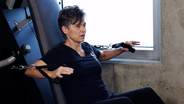 an image of a woman using an ARX workout machine.
