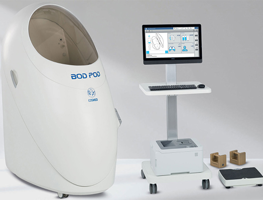 an image of a Bod Pod device that customers would step into. There is a computer monitoring screen next to the Bod Pod that displays the results of the test.