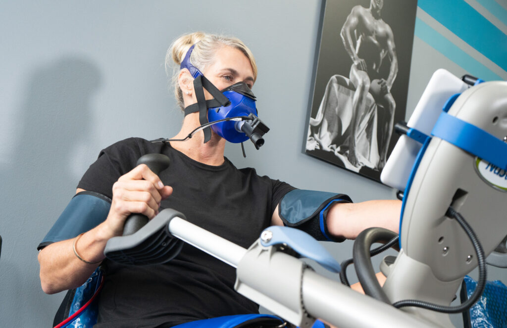 an image of an elderly woman using advanced technology to improve the high intensity training she is doing at a gym