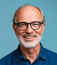 a headshot of an elderly man with glasses smiling at the camera