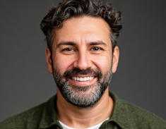 a headshot of a middle aged man smiling at the camera