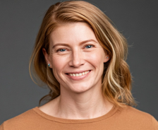 a headshot of a woman with brown hair smiling at the camera